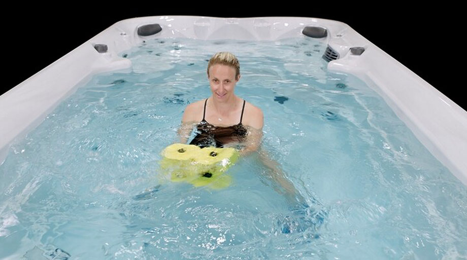 Séance d’aquagym dans un jacuzzi de nage avec haltère aquatique et chevillères